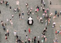 people gathered watching a panda mascot