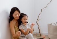 mother and daughter sitting on the floor at home