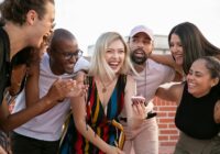 excited young diverse friends celebrating birthday of cheerful woman on terrace