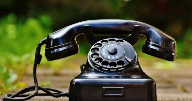 selective focus photography of black rotary phone