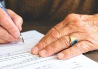 person signing document paper