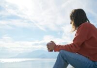 person sitting in front of body of water