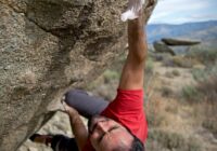 man climbing on gray concrete peak at daytime